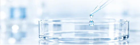 Laboratory pipette above a glass dish